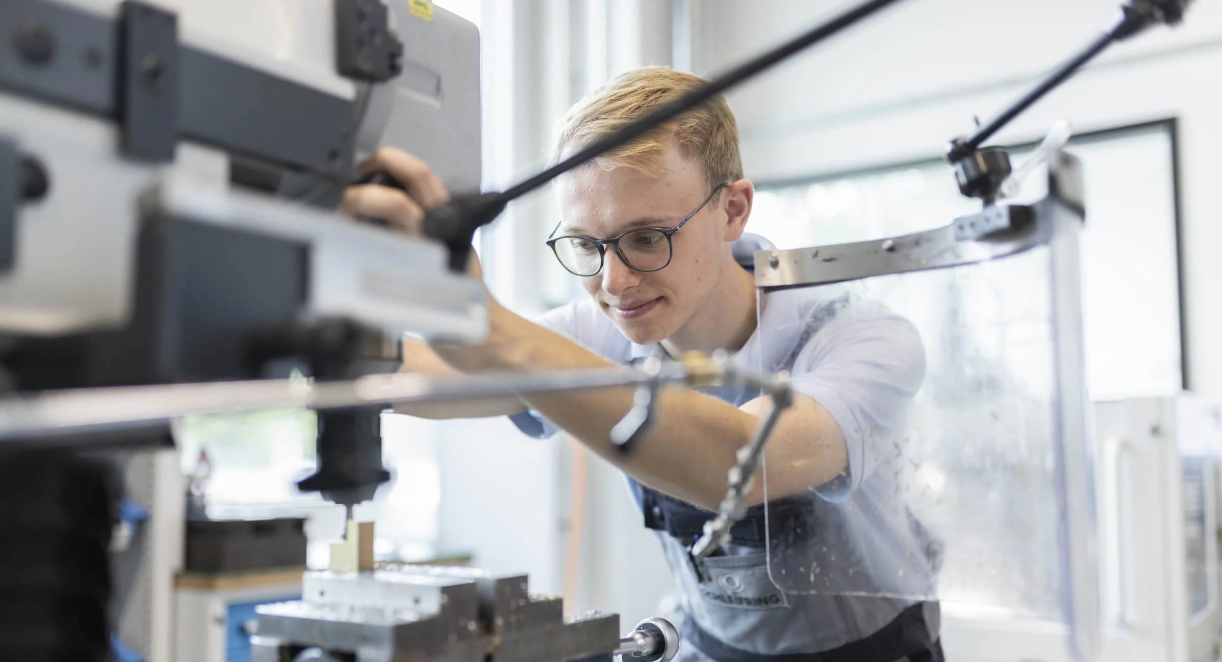 Mitarbeiter bei SCHLEIFRING bedient eine Maschine in der Produktion.