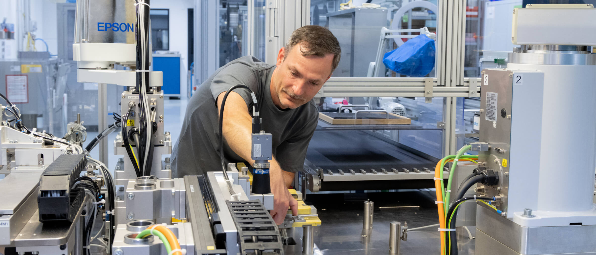 Mitarbeiter bedient eine moderne Industrieanlage mit automatisierten Fertigungskomponenten