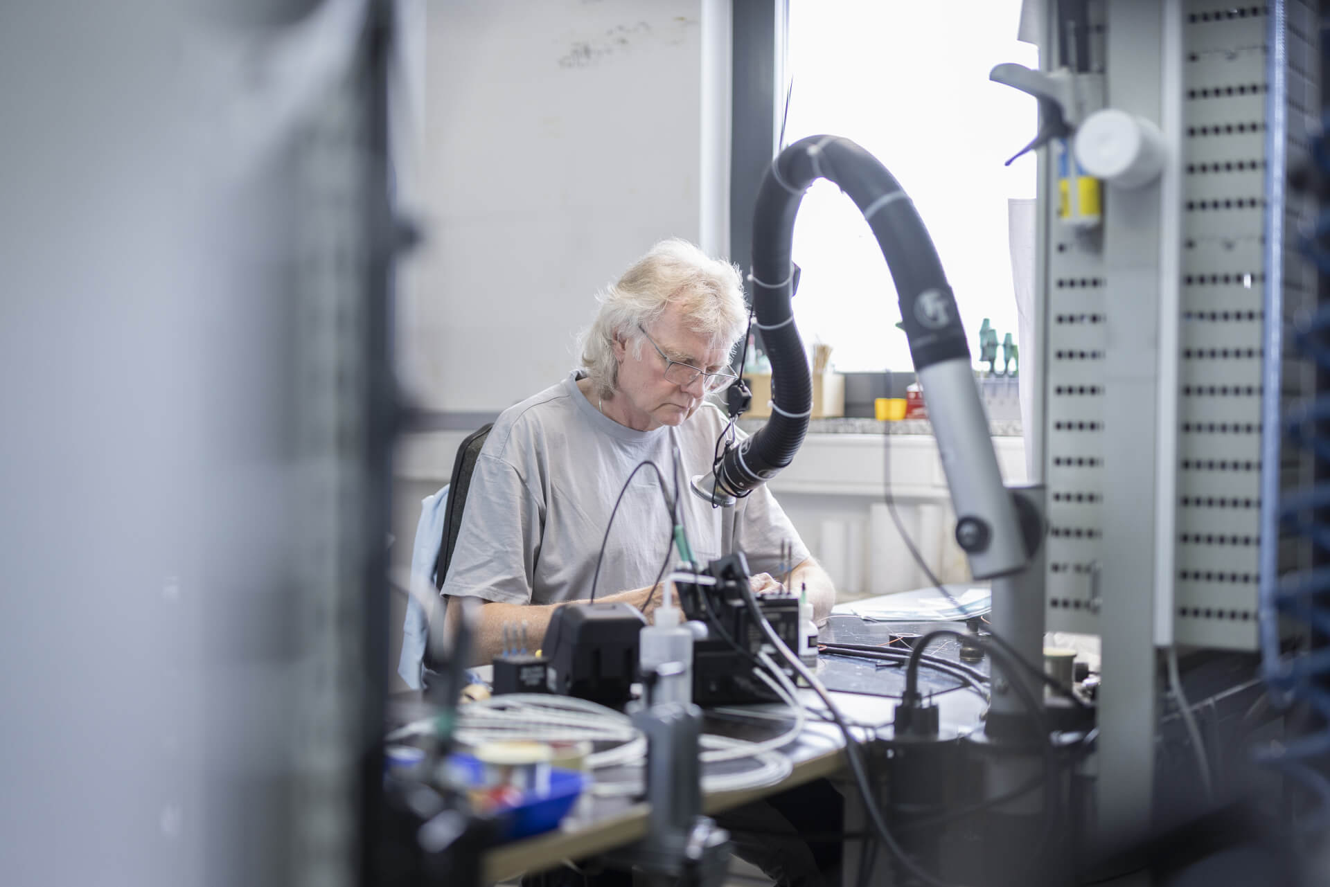 Elektroniktechniker führt Lötarbeiten an einem spezialisierten Arbeitsplatz durch.