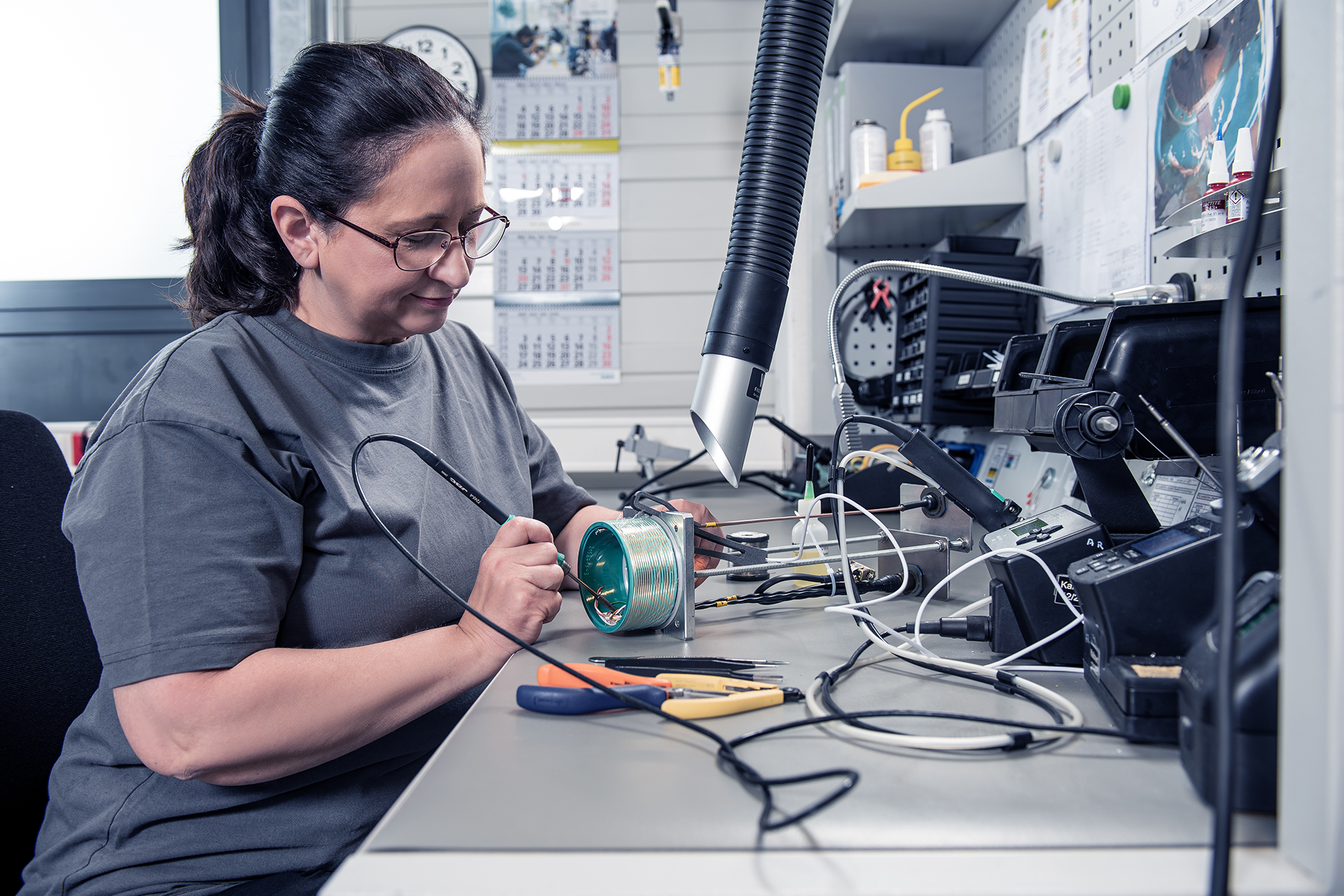 SCHLEIFRING Mitarbeiterin bei der mechanischen Prüfung eines Elektronik-Bauteils.