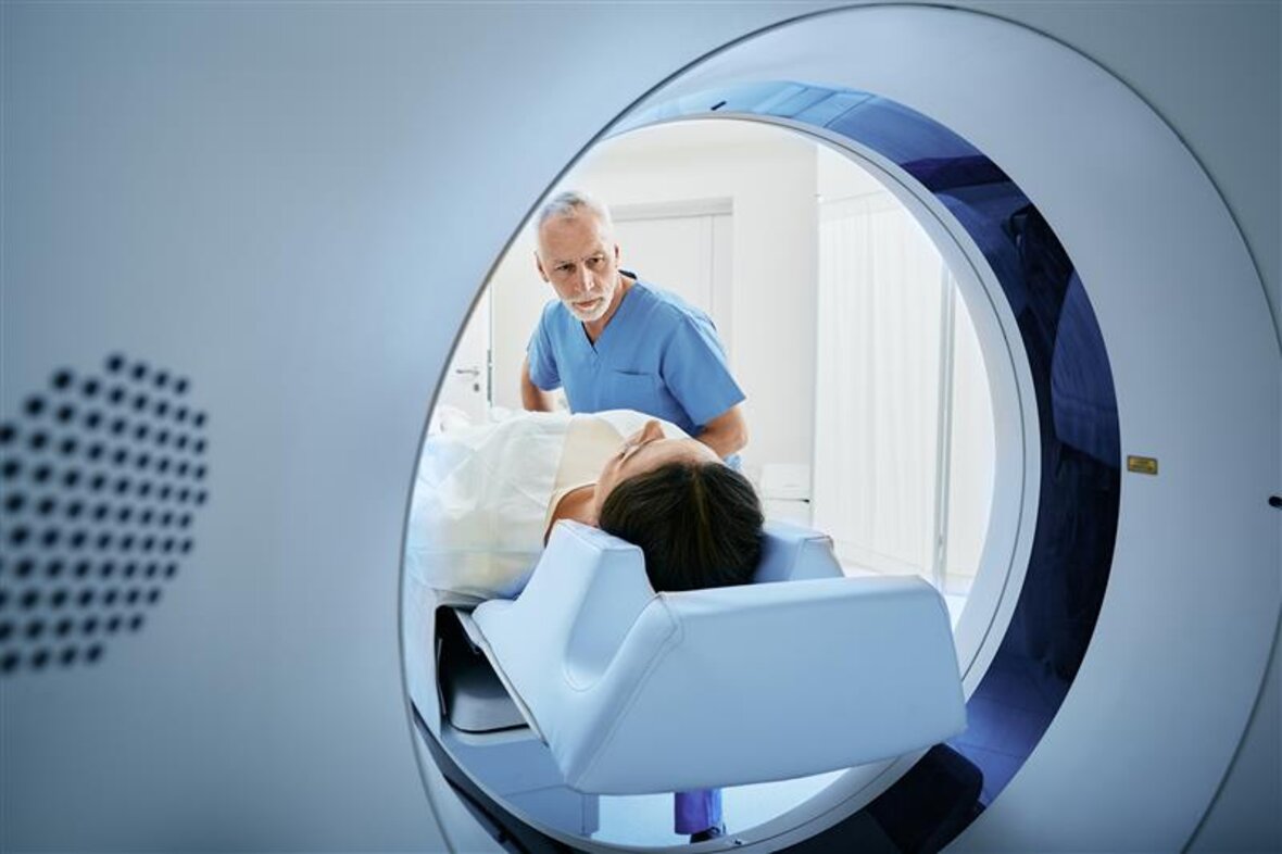 Ein Patient wird für eine CT-Untersuchung vorbereitet, unterstützt von medizinischem Fachpersonal – moderne Bildgebung mit kontaktloser Datenübertragung.