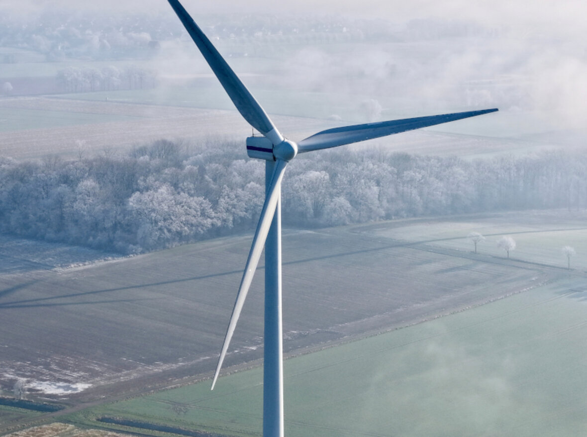 Windkraftanlage auf einem Feld aus der Vogelperspektive an einem nebligen Morgen