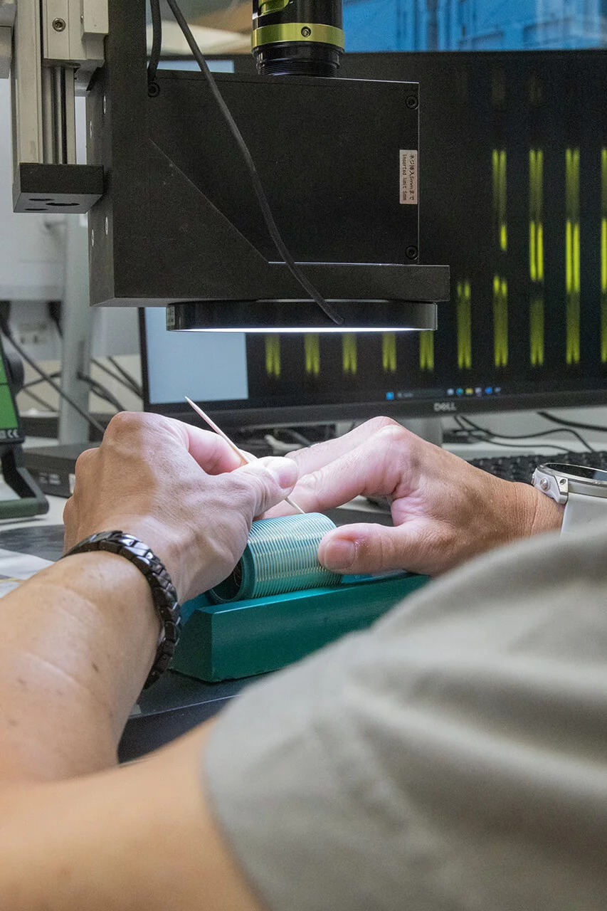 Nahaufnahme der Hände eines SCHLEIFRING Mitarbeiters in der Montage.