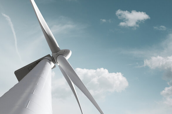 Nahaufnahme einer modernen Windenergieanlage mit blauem Himmel im Hintergrund