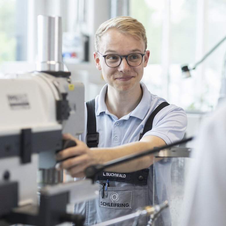 Auszubildender bedient konzentriert eine Drehmaschine im Ausbildungszentrum.